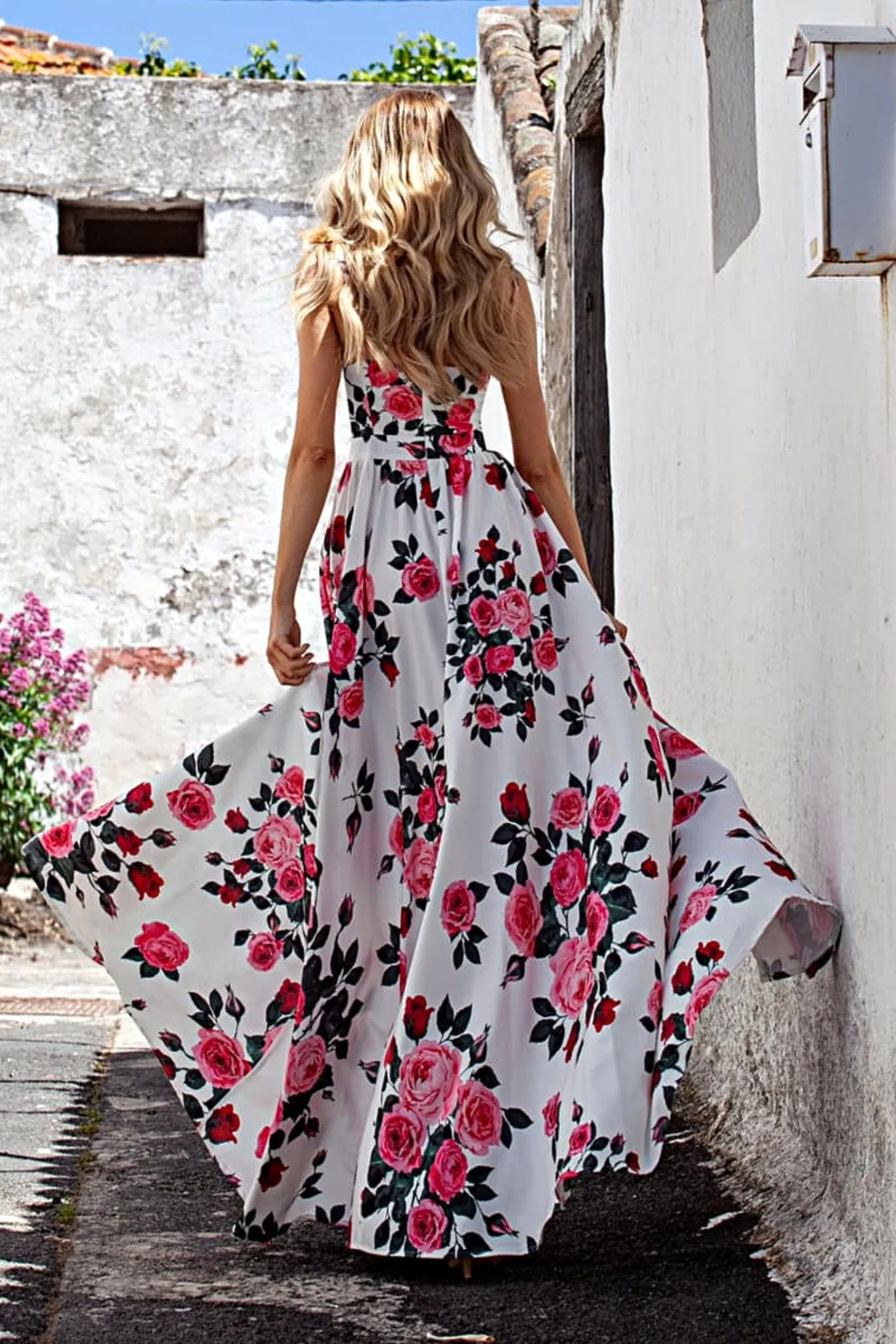 Abito lungo svasato estivo bianco a fantasia floreale fucsia e fiori verdi con spacchi laterali